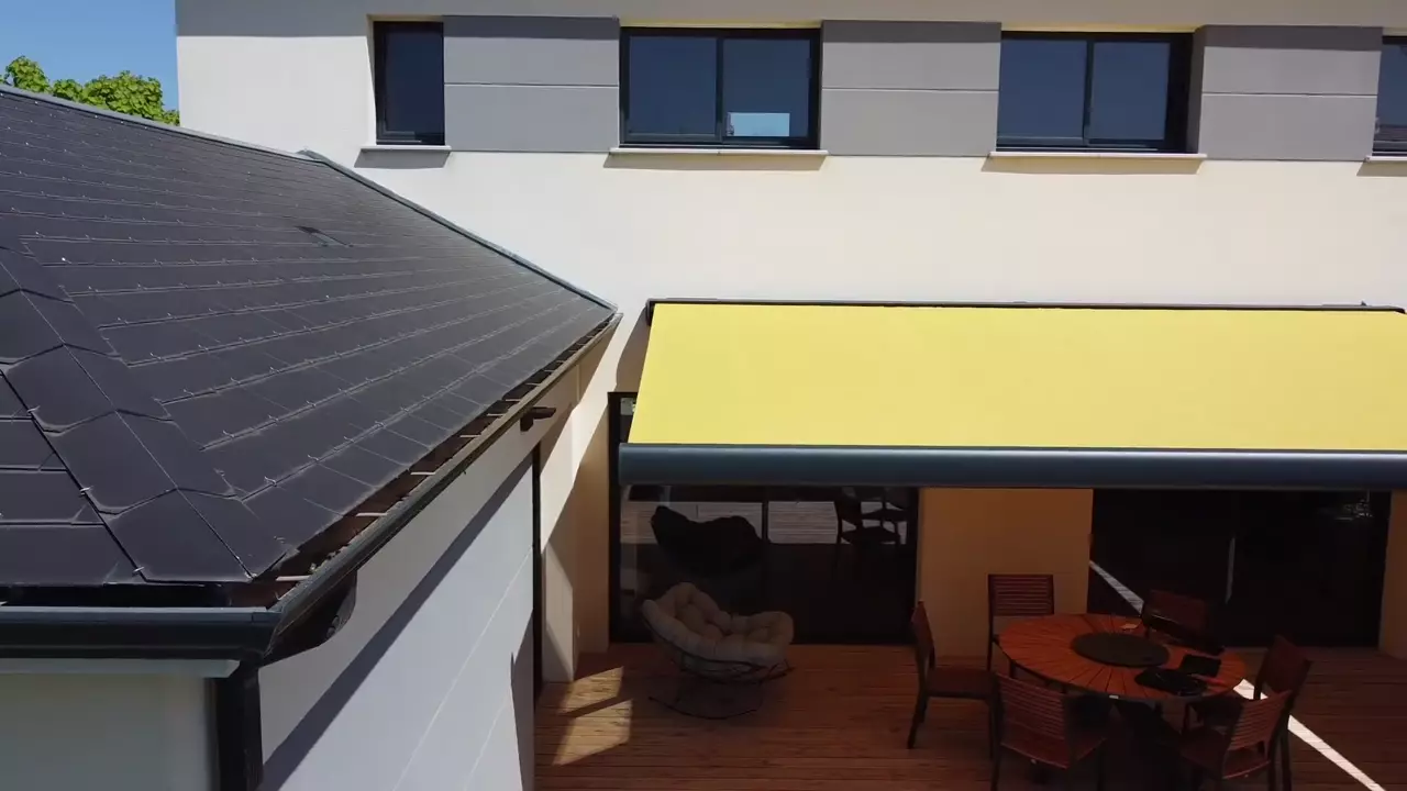 Toiture en ardoise et façade d'un bâtiment filmées par drone à basse altitude